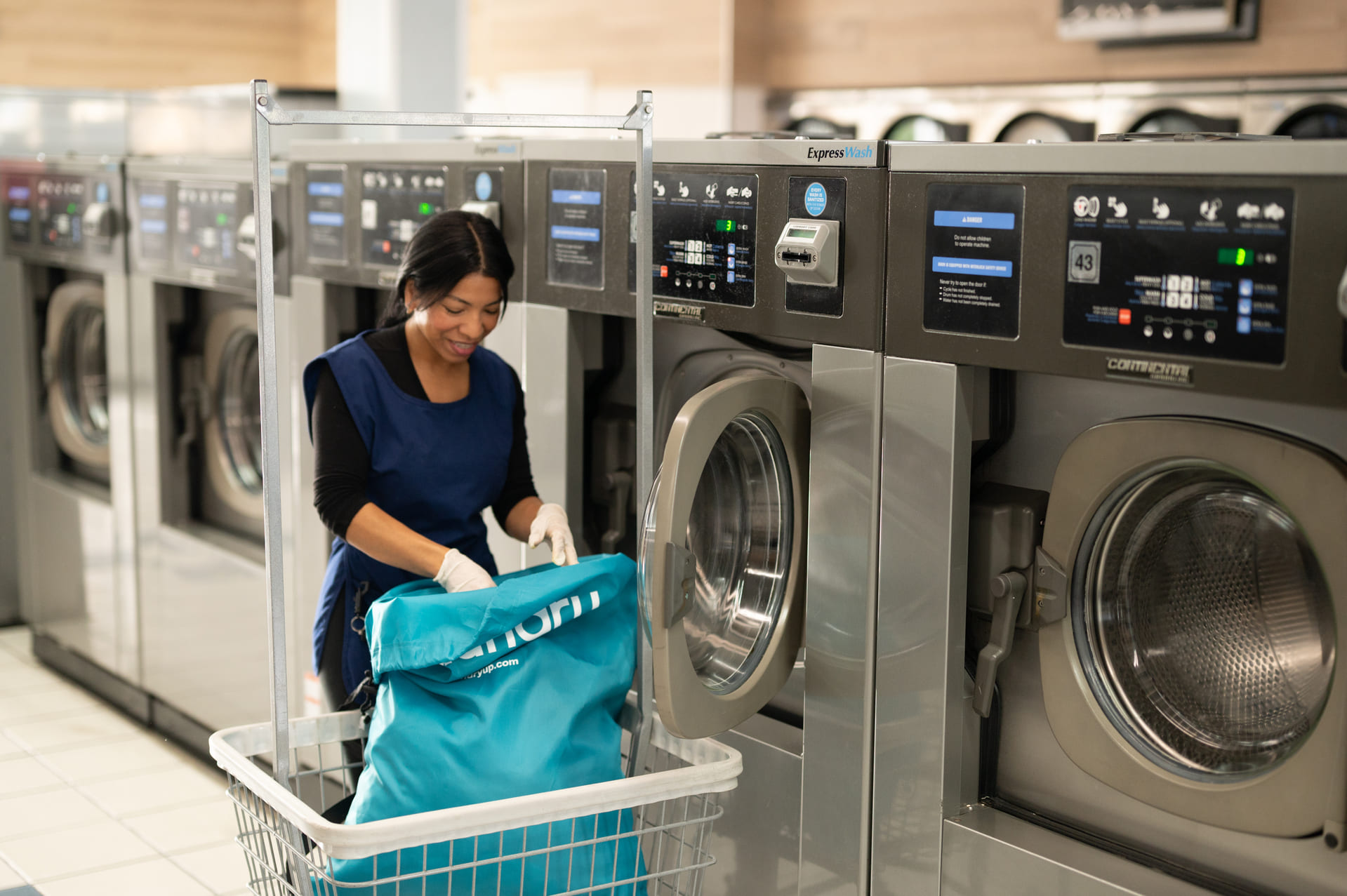 Superior Laundry team member placing clothes into a front-load washer